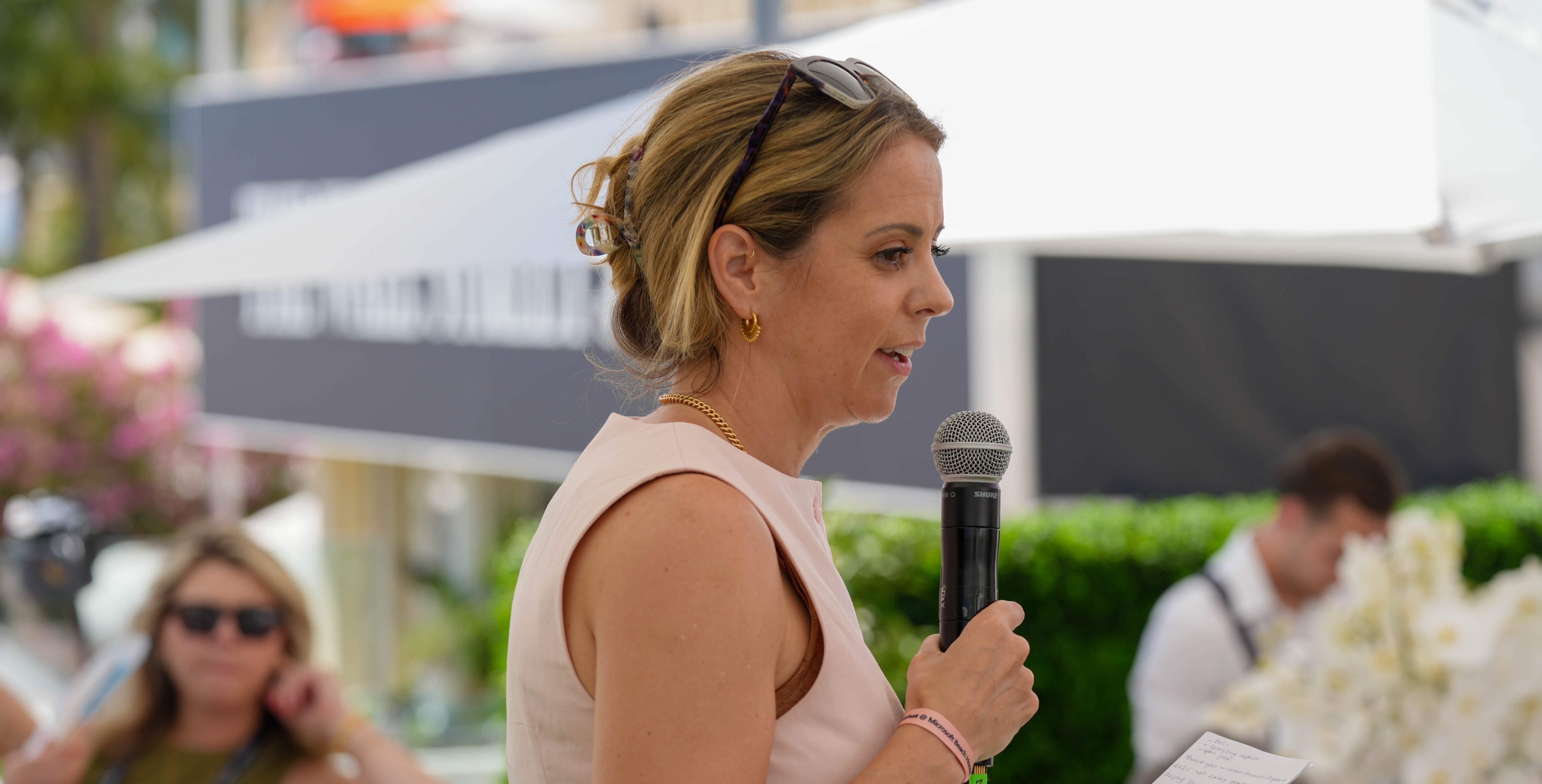 woman with blonde hair speaking into microphone