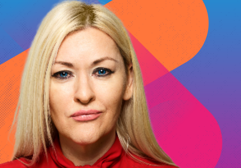 Professional headshot of a blonde woman looking into the camera wearing a red shirt 